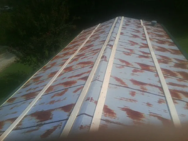 Rusted metal roof panels with new wood purlins before replacement — Storm Damage Roof Repair in Paris by Roofing Brothers
